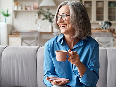 Older Buda patient with youthful smile from dental implants