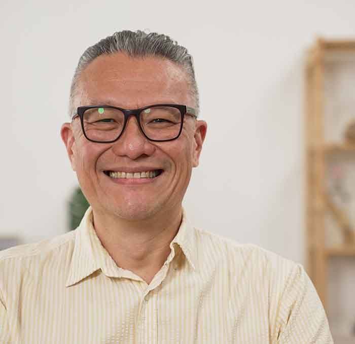 Dentist pointing to model smile with dentures