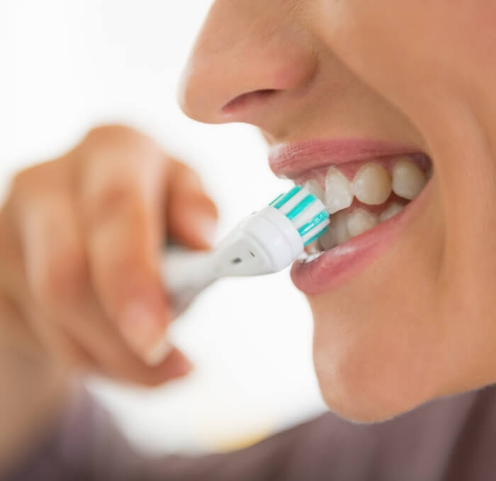 Person brushing teeth after tooth extraction