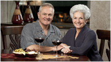 Smiling senior man and woman sitting at restaurant table