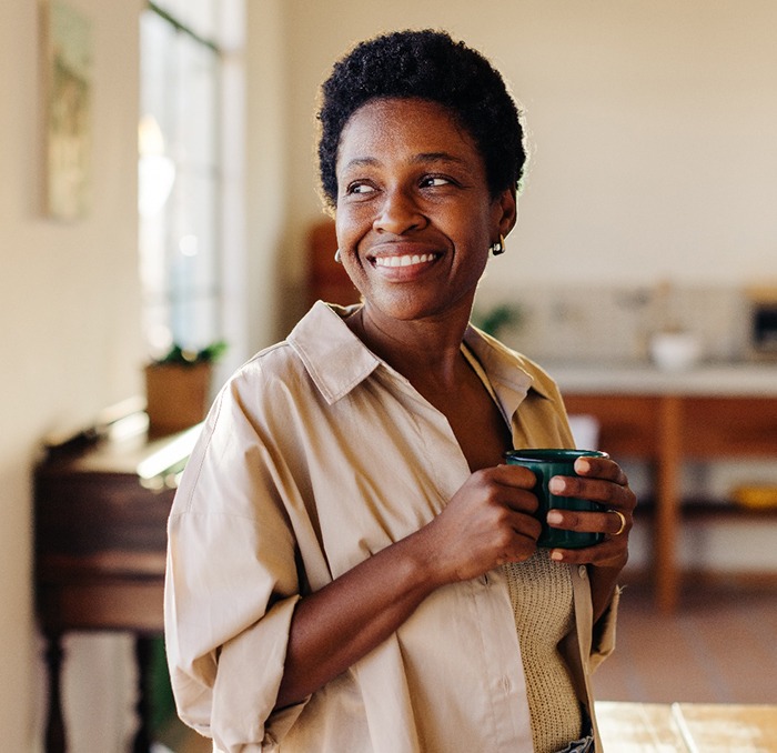 Smiling woman enjoying coffee at home