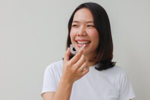 Woman putting her Invisalign trays in after adjusting to them