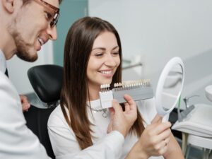 Patient looking at veneers and smiling into mirror.