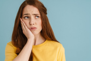 Woman holding her jaw because her tooth hurts